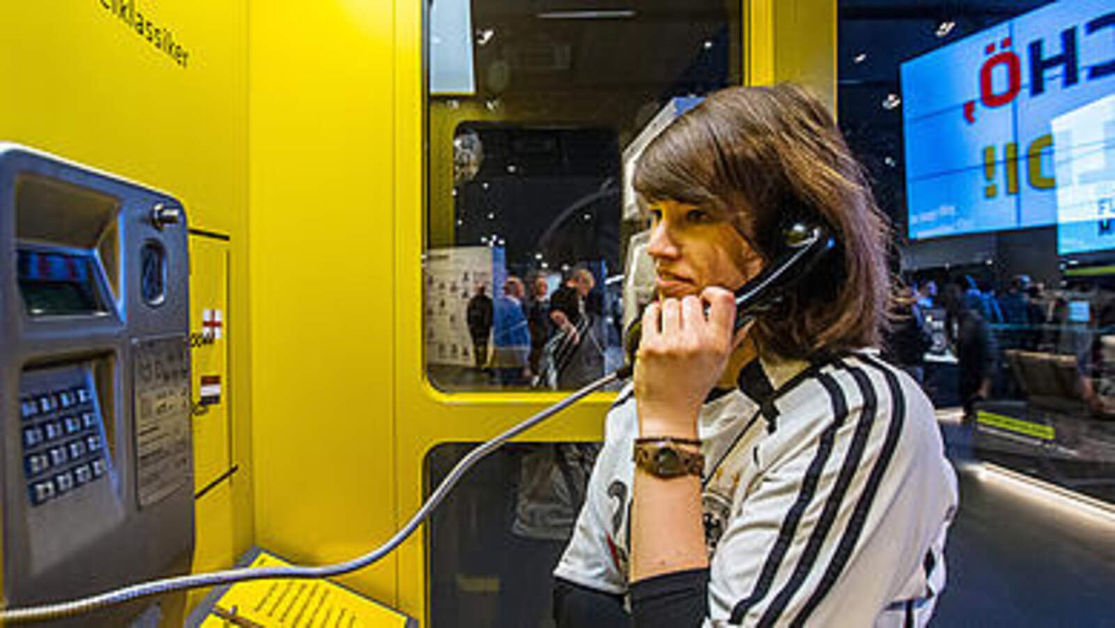 Eine Besucherin nutzt eine Telefonzelle im Fußballmuseum