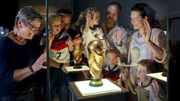 Eine ganze Familie staunt über die Original-WM-Pokale