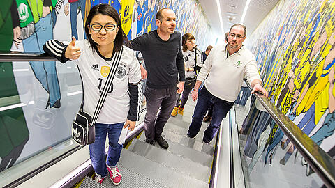 Internationale Gäste fahren mit der Rolltreppe ins 2. Obergeschoss des Deutschen Fußballmuseums, wo die Ausstellung beginnt