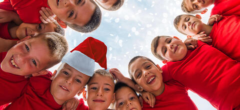 Kinder mit Nikolausmütze stehen im Kreis